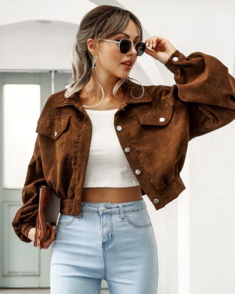 Blouson aviateur femme, à manches bouffantes, d'été, col à rabat, boutonnage simple, de couleur marron, porté par une femme avec lunettes de soleils