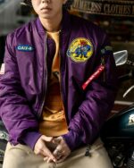 Blouson aviateur vintage violet avec broderie pour homme porté par un homme sur fond gris