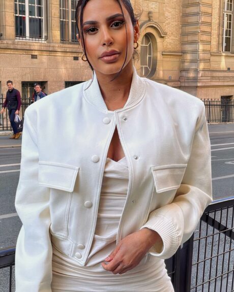 Blouson blanc court avec boutons et poches pour femme porté par une femme sur fond de rue