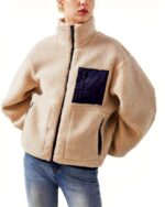 Blouson chaud femme style laine beige porté par une femme dont on ne voit pas le visage et sur fond blanc