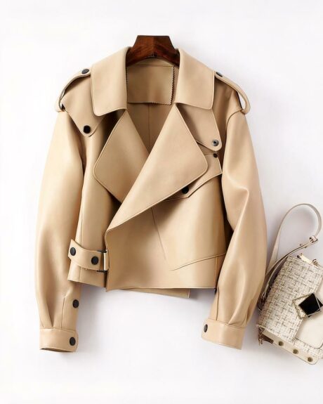 Blouson cuir femme beige coupe aviateur sophistiqué posé à plat près d'une sac à main