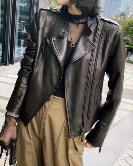 Blouson cuir femme coupe aviateur porté par une femme dont on ne voit pas le visage dans une rue