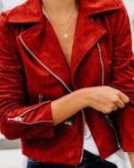 Blouson style daim femme mi-saison doux rouge porté par une femme dont on ne voit pas le visage