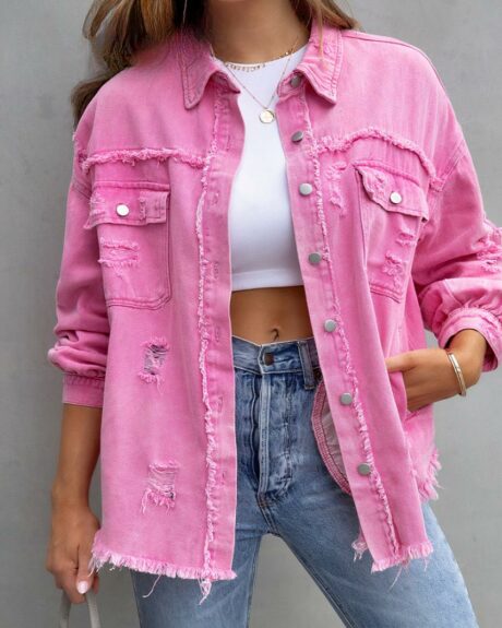 Blouson en jean vintage effiloché avec déchirures pour femme sur une femme sur fond gris