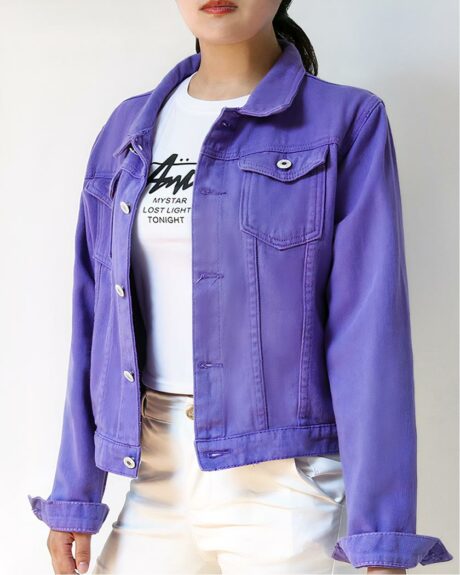 Blouson en jean violet décontracté pour femme porté par une femme sur fond gris