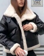 Blouson fourré de style motard en simili cuir pour femme porté par une femme sur fond gris