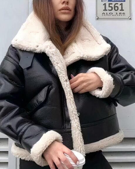 Blouson fourré de style motard en simili cuir pour femme porté par une femme sur fond gris
