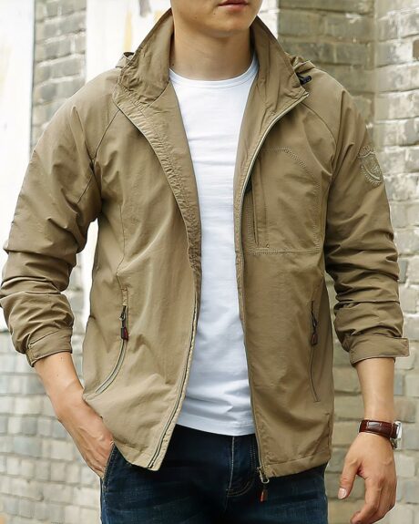 Blouson imperméable homme à capuche et coupe-vent, de couleur marron, porté par un homme debout