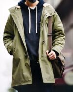 Blouson imperméable homme, avec capuche, de couleur vert kaki,mi long, porté par un homme