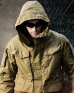 Blouson imperméable homme, coupe-vent, séchage rapide, à capuche, de couleur marron, porté par un homme capuché avec lunettes de soleils