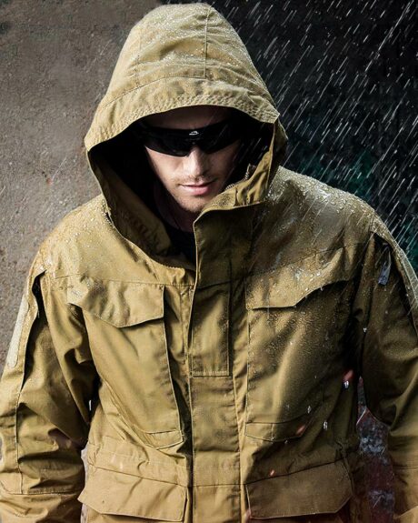 Blouson imperméable homme, coupe-vent, séchage rapide, à capuche, de couleur marron, porté par un homme capuché avec lunettes de soleils