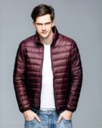Blouson matelassé en plumes ultra léger pour homme sur un homme sur fond gris