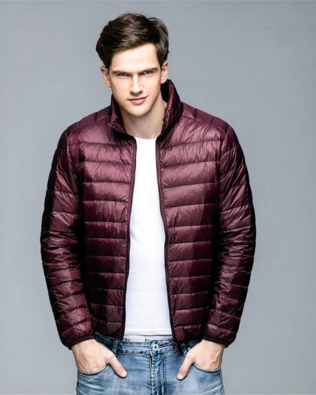 Blouson matelassé en plumes ultra léger pour homme sur un homme sur fond gris
