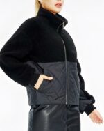 Blouson matelassé femme avec fourrure polaire noir porté par une femme sur fond blanc