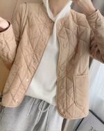 Blouson matelassé femme court et fin avec boutons pression marron porté par une femme dont on ne voit pas le visage