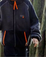 Blouson polaire homme, bicolore à capuche, de couleur gris et noir porté par un homme se trouvant debout dans la forêt