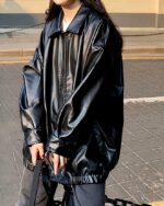 Blouson simili cuir femme ample noir porté par une femme dans la rue