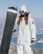 Blouson ski femme beige avec capuche porté par une fille en snowboard