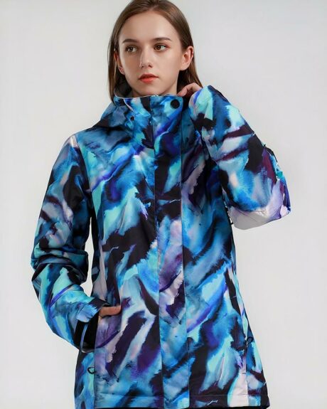Blouson ski femme coupe-vent imperméable bleu porté par une jeune fille sur fond gris