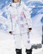 Blouson ski fille blanc avec dessins couleur pastel porté par une fille dans la neige dont on ne voit pas le visage