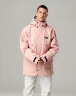 Blouson ski homme, imperméable, coupe-vent, de couleur rose, avec une capuche, porté par un homme debout