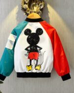 Un blouson style bomber de dos, avec imprimé mickey sur fond blanc, une manche rouge et un manche vert