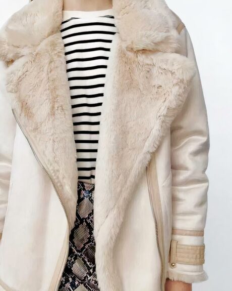 Blouson aviateur femme mi-long en simili cuir blanc et beige porté par une jeune femme dont on ne voit pas le visage