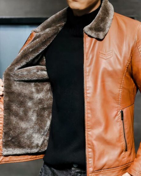 Blouson fourré avec col en fourrure synthétique en simili cuir porté par un homme sur fond gris