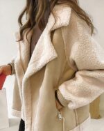 Blouson fourrur style daim beige porté par une femme dont on ne voit pas le visage