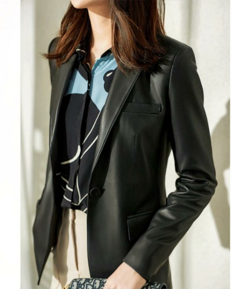 Une femme debout portant un blouson en cuir noir style blazer