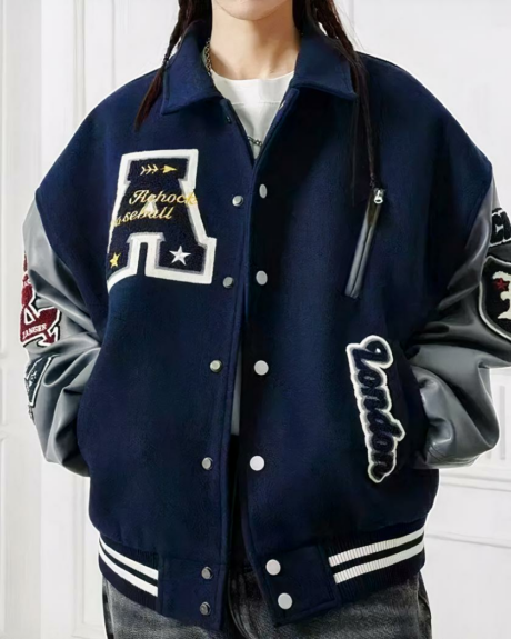 Une femme debout portant un blouson teddy brodé avec des lettres américaines