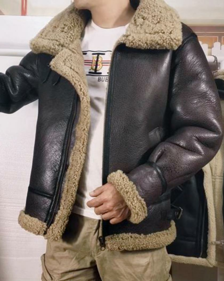 Un homme portant un blouson en cuir marron à col rabattu fourré