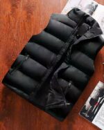 Blouson sans manches noir pour homme à fermeture ouverte posé sur une table en bois