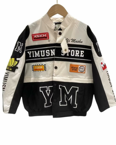 Blouson noir et blanc de moto pour fille avec des inscription sur les parties noires et des logos sur les parties blanches et sur les manches. Fermetures à pressions. La partie noire en bas du blouson est détachable. Sur fond blanc.