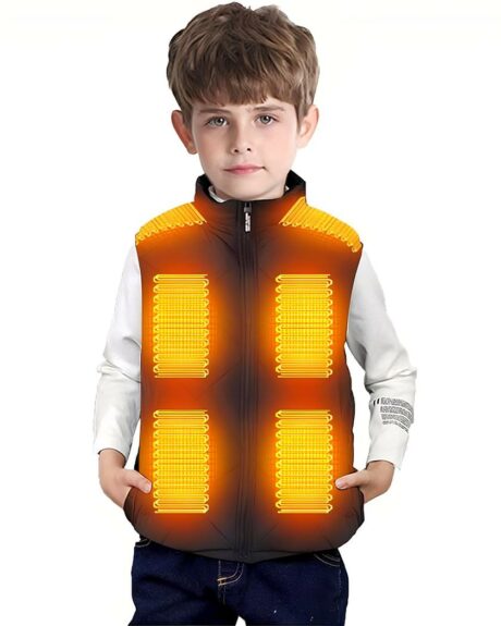 Jeune garçon portant un blouson sans manches noir sur lequel apparaissent les symboles orange qui indiquent qu'il est chauffant. Il porte un pantalon noir et un haut à manches longues blanc.