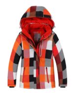 Blouson de ski pour enfant à carreaux rouge, orange, noir et blanc, l'intérieur est rouge, la capuche est relevée vers le haut. 2 poches latérales et 1 poche sur la poitrine.