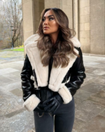 Une femme brune dans la rue portant un blouson bombardier noir à col fourré